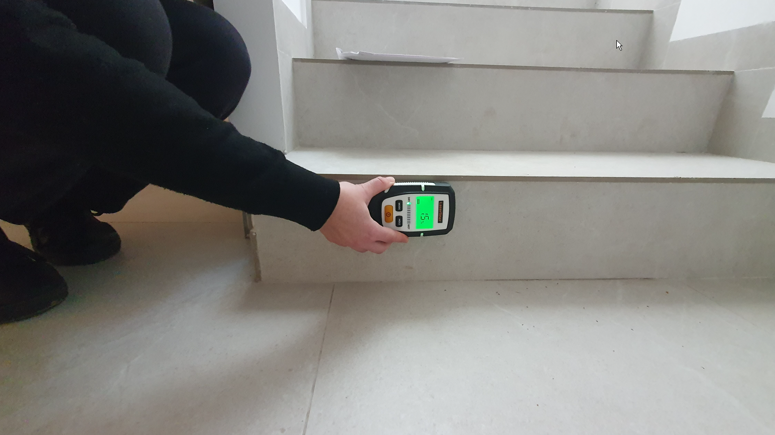 Vor-Ort-Untersuchung: Messung mit einem Feuchtigkeitsmessgerät an einer Treppe